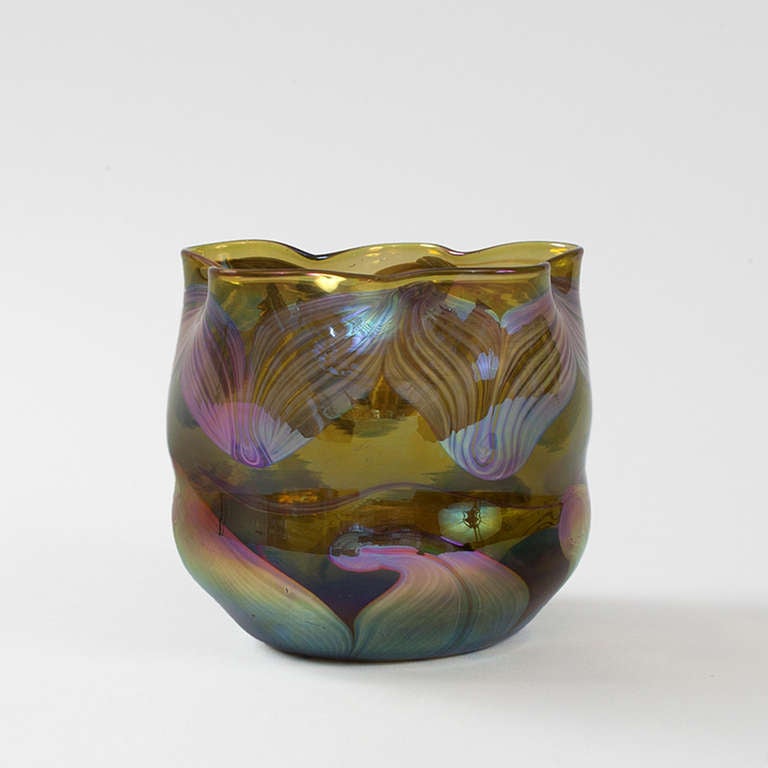 An early Tiffany Studios New York favrile glass vase with pulled decoration. The vase features iridescent swirls in pinks and blues on a translucent pale brown background. Circa 1894.

Original Tiffany paper label. 

A vase with similar decoration
