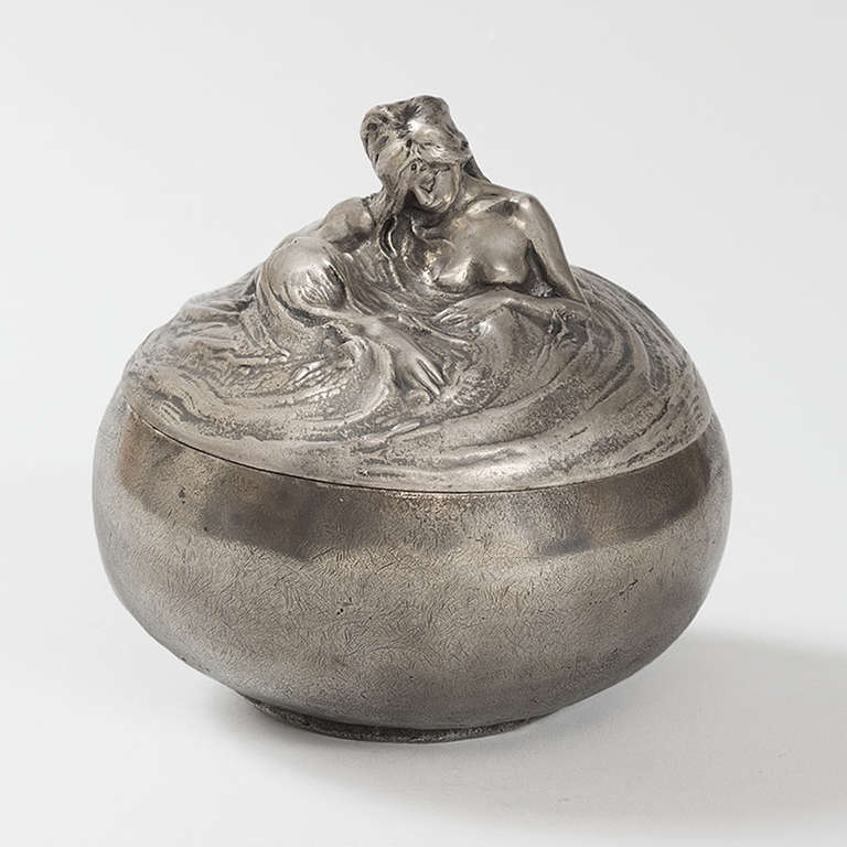 A French Art Nouveau silvered bronze figural covered box by Alexandre Charpentier. 

A similar object is pictured in: The Paris Salons 1895-1915, Vol. V: Objects d’Art and Metalware, by Alastair Duncan, Woodbridge, Suffolk: Antique Collectors'