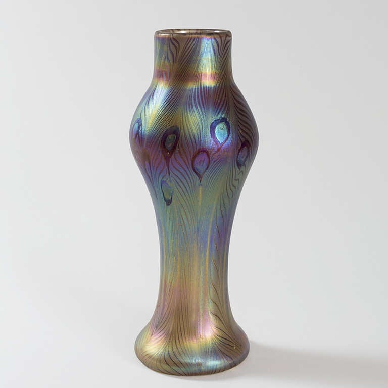 A Tiffany Studios New York iridescent Favrile glass vase decorated with a peacock feather motif in blues and green.  Circa 1900.

A vase with similar motif is pictured in: Tiffany Favrile Glass and the Quest of Beauty, by Martin Eidelberg, New