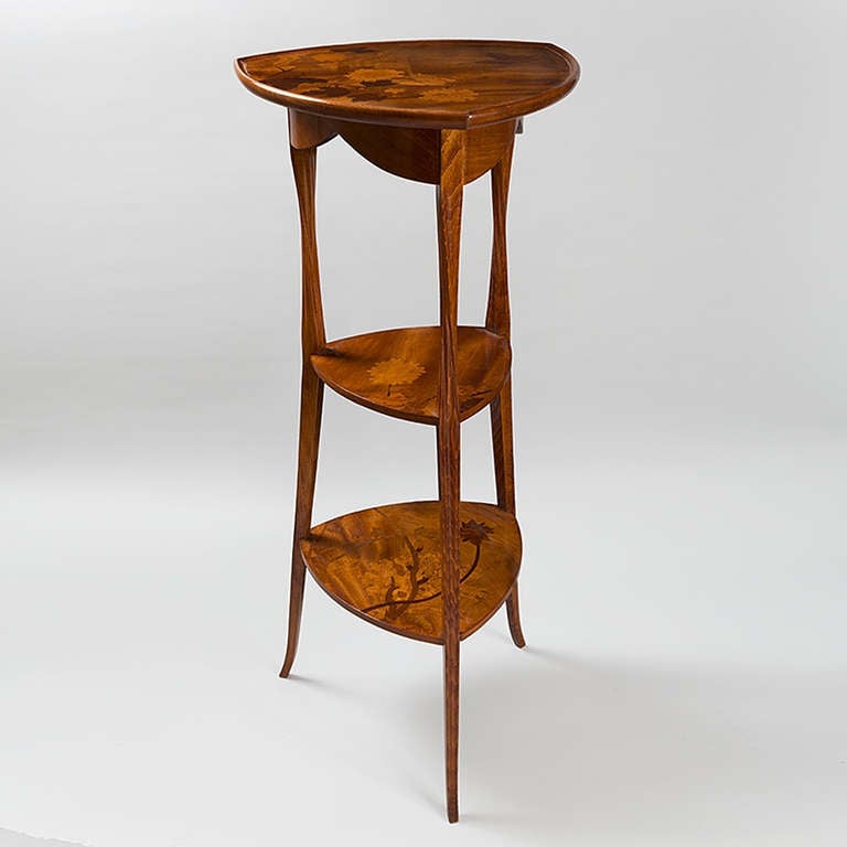 French Art Nouveau three-tier tri-cornered pedestal, by Louis Majorelle, in carved walnut with pond lily fruitwood marquetry. Circa 1900.

Signed, 