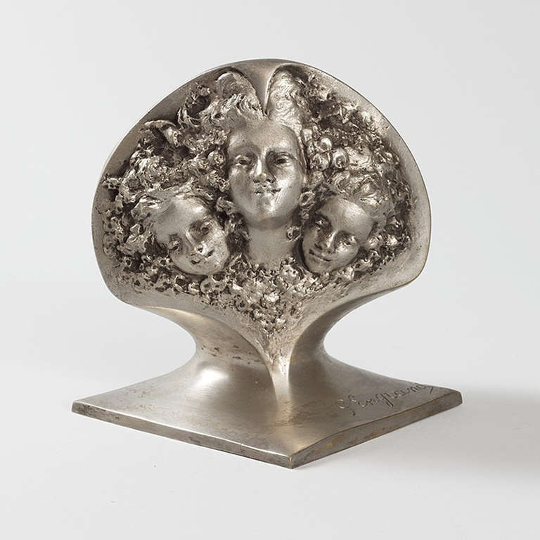 A French Art Nouveau silvered bronze figural jardiniere by Georges Engrand. The vase depicts the head of a woman. Her hair curls around the heads of her two children, placed on either side of her.  Circa 1900.

(MG #15248)