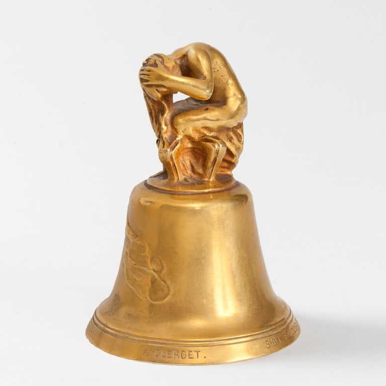 A French Art Nouveau gilt bronze dinner bell by Alexandre Clerget (1856-1931). A nude female bather is seated atop the bell, forming the handle.  Her disheveled hair and drapery hang downwards and drape onto the surface of the bell.
