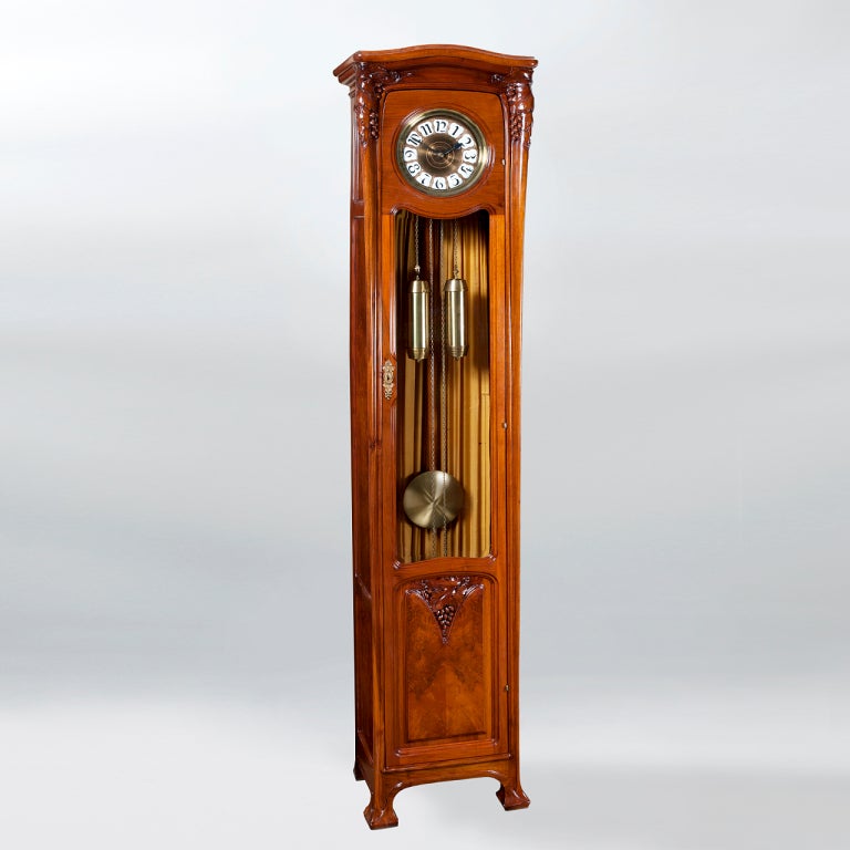 A French Art Nouveau walnut and burl walnut floor clock  with bronze and porcelain face. From the School of Nancy. 
(MG Inventory # F14431)