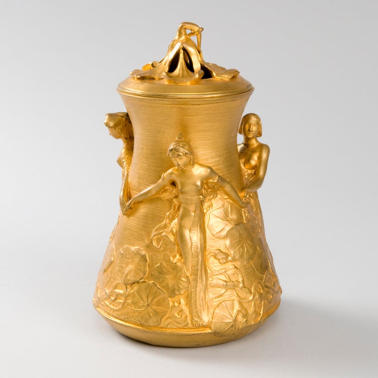 A French Art Nouveau gilt bronze covered jar by Alexandre Clerget, featuring a decoration of three dancing maidens amidst flowers. Model exhibited at the Paris Universal Exhibition of 1900. Pictured in: Siot-Décauville, Fondeur Editeur: Bronzes &