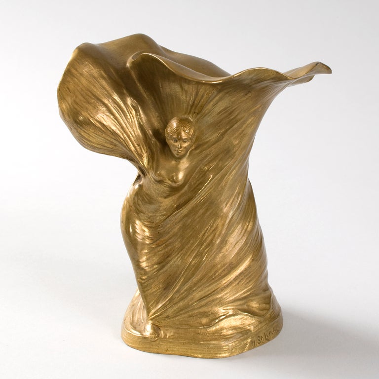 A French Art Nouveau gilt bronze vase by Hans Stoltenberg-lerche representing Loi?e Fuller, featuring a depiction of a woman enmeshed in swirling draperies. The early modern dancer Loi?e Fuller is generally considered the human embodiment of the Art
