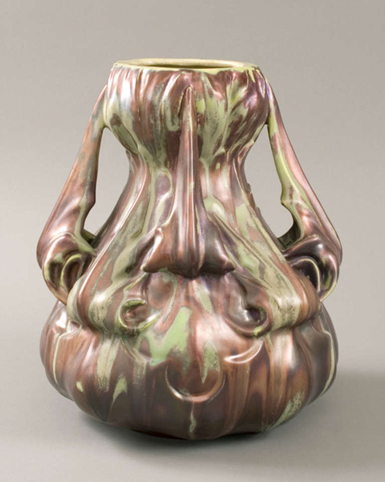 A French Art Nouveau ceramic vase designed by Ernest Bussière and produced by Keller et Guérin, featuring an iridescent milky-green glaze with earthy purples and metallic highlights. 
Produced circa 1895-1899.  Signed 