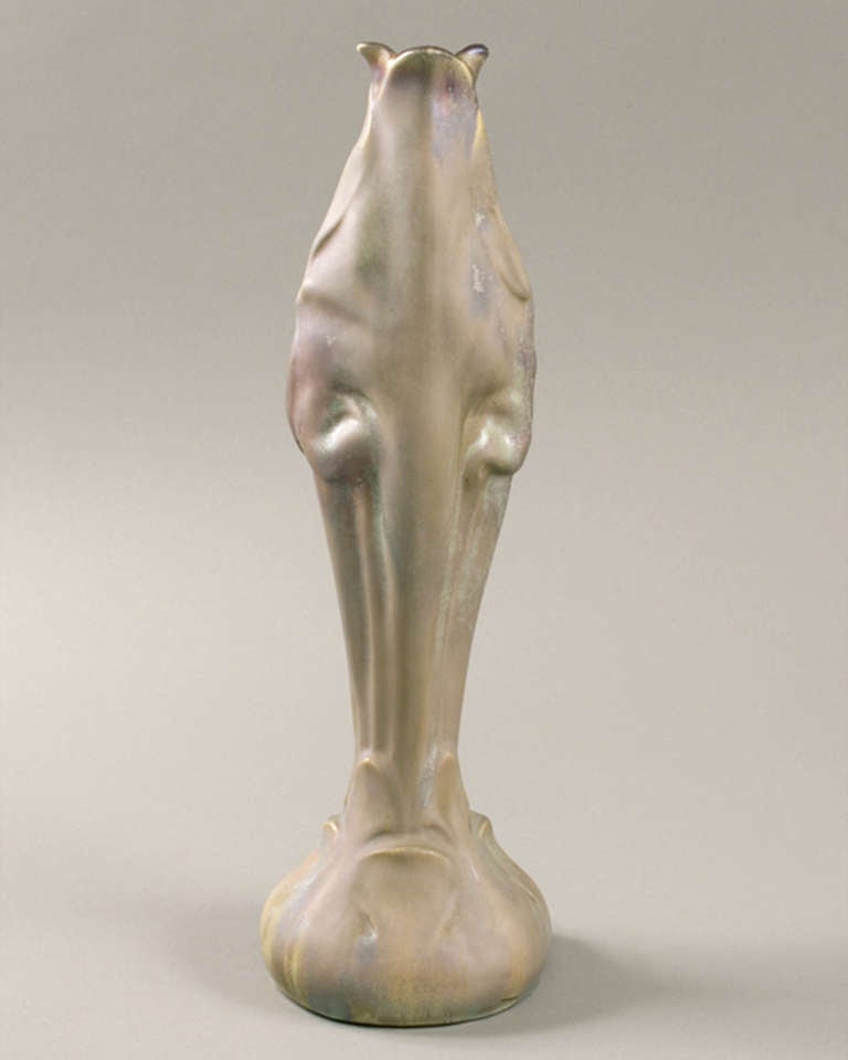 A French Art Nouveau vase by Keller and Gue´rin, from a design by Ernest Bussie`re, featuring the form of a closed flower in relief, with iridescent milky-green and mauve glazes, circa 1900.

Signed, “K.G. Lune´ville Bussie`re”. 

A similar vase