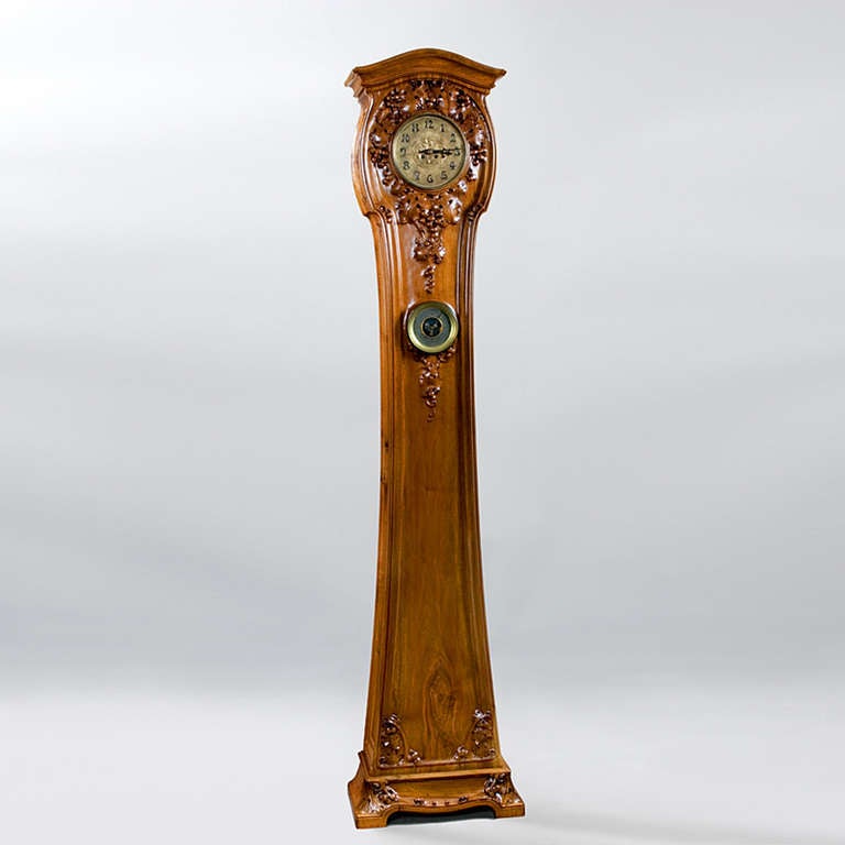 A French Art Nouveau case clock by Louis Majorelle, featuring a carved floral design in walnut, and further enhanced with a working barometer in the center.  Circa 1900.  

Signed, 