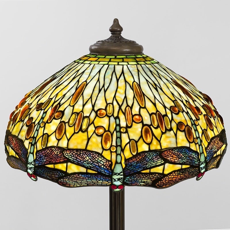 A Tiffany Studios New York glass and bronze “Drophead Dragonfly” floor lamp, featuring a lower row of mottled pale blue dragonflies with wings of amber, white and yellow glass, and blazing red jeweled eyes. Above the dragonflies, the shade is