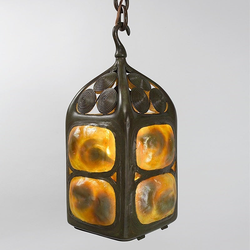 A Tiffany Studios New York glass and bronze Turtleback Tile hanging lantern, featuring eight iridescent Favrile glass Turtleback tiles set into a decorated patinated bronze holder. The lantern is further enhanced with a Turtleback trapdoor at
