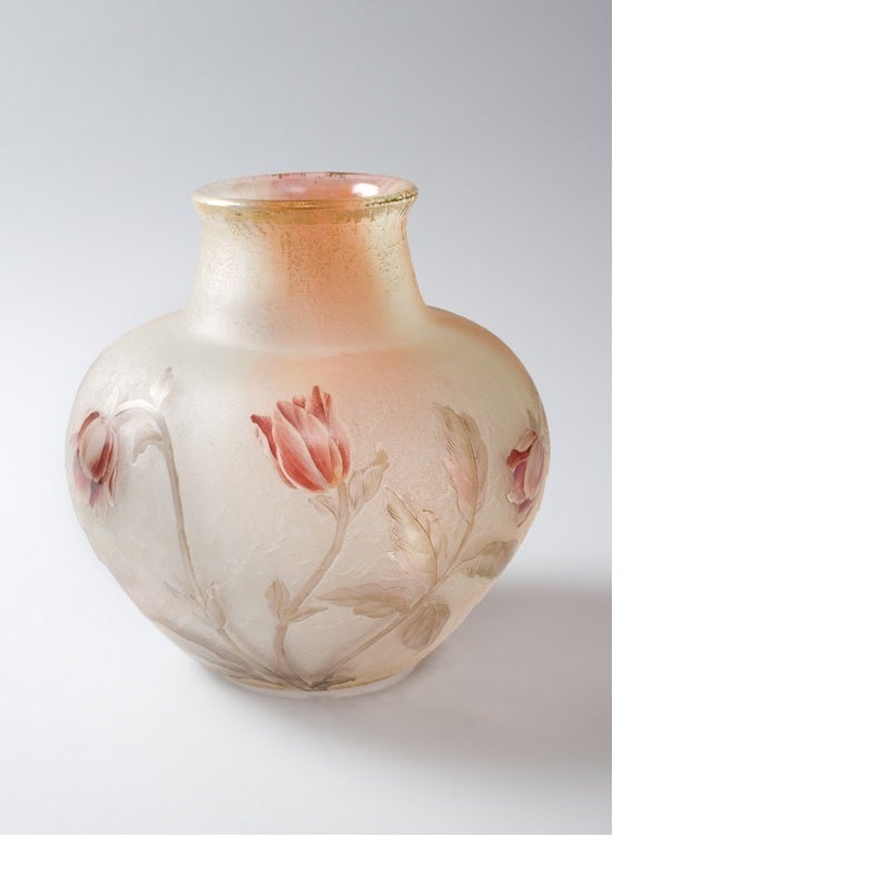 A French Art Nouveau cameo glass vase by Daum, featuring carved crimson flowers on a textured pink and white translucent ground. The top of the vase is rimmed in gold. Circa 1900.  Signed, “Daum Nancy”.

A vase with similar decoration is pictured