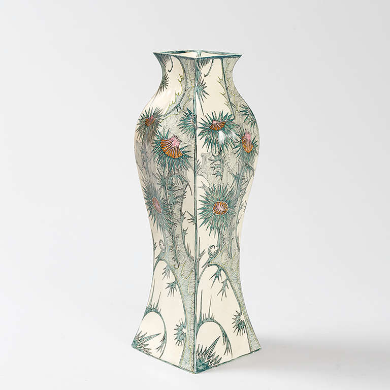A Dutch Jugendstil Vase by Samuel Schellink with thistle decoration for Rozenburg. The vase depicts orange-pink flowers surrounded by spiky blue-green leaves and stems on a white background. Circa 1905. (MG #15772)