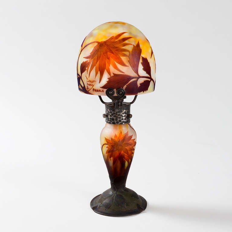 A French Art Nouveau lamp by Daum. A boudoir lamp featuring auburn-hued carved cameo floral motif over a soft pink, yellow and lavender background.  Circa 1890s.

A similar lamp (using a different flower) is pictured in: Daum Nancy: Maîtres