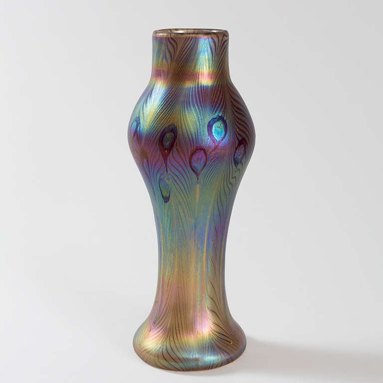 A Tiffany Studios New York iridescent Favrile glass vase decorated with a peacock feather motif in blues and green, circa 1900.

A vase with similar motif is pictured in: Tiffany Favrile glass and the quest of beauty, by Martin Eidelberg, New
