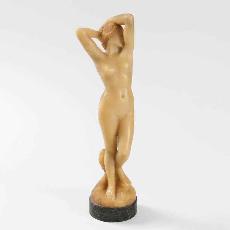 A French Art Nouveau wax sculpture, depicting a nude maiden resting her hands on top of her head with an owl at her feet. The piece is signed “H. Vernbet.” The graceful body shape and use of the owl leads us to believe that this very well could be a