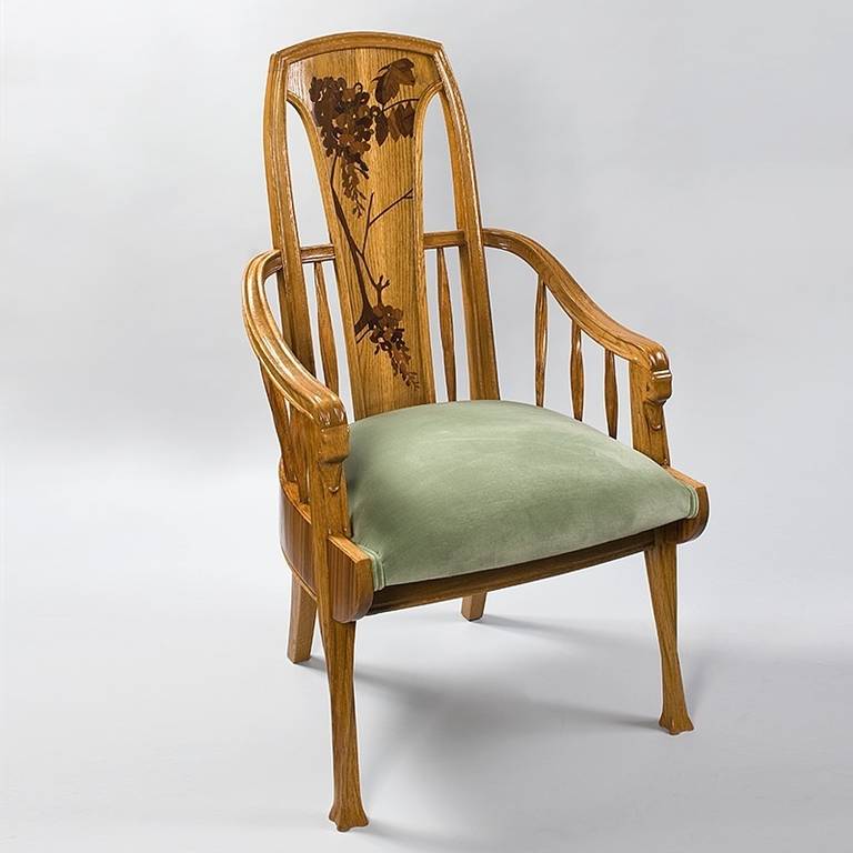 A pair of French Art Nouveau marquetry armchairs by Louis Majorelle, featuring inlaid marquetry on the chair backs in a floral motif, and carved “duck bill” arms.  Circa 1900.  Similar example pictured in: Louis Majorelle: Master of Art Nouveau