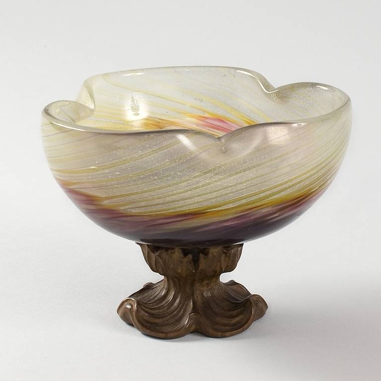 A French Art Nouveau glass and wood footed bowl by Emile Galle´, featuring a multicolored pinched-sided glass bowl in yellow, purple, and green. The bowl sits atop a carved walnut foot with openwork floral design and scrolled base, circa 1900.