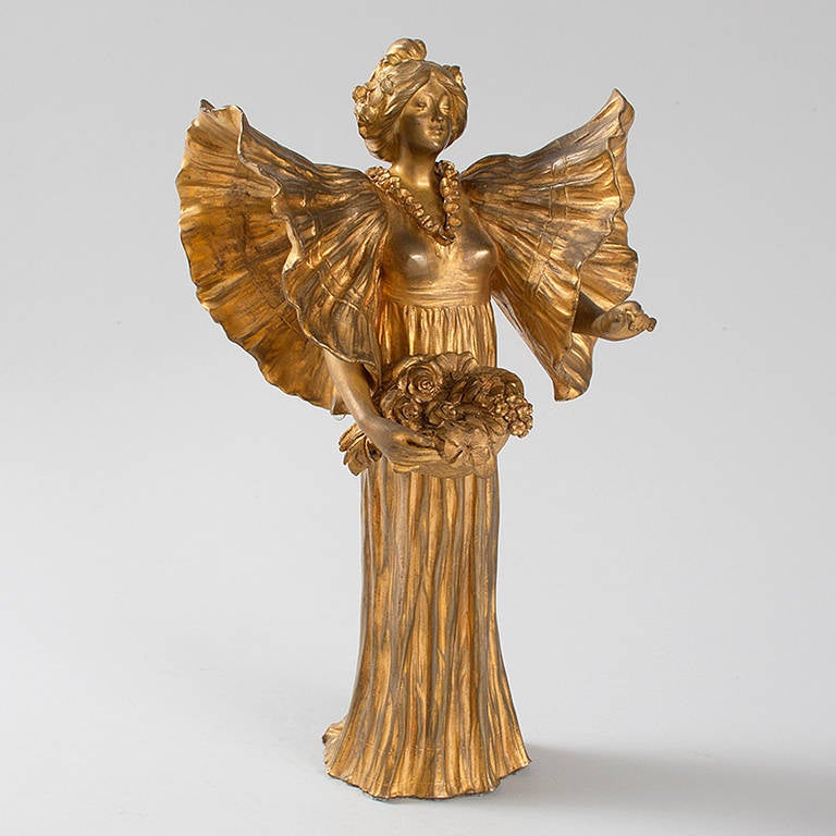 A French Art Nouveau gilt bronze sculpture of a woman holding a basket of flowers. Circa 1900. Pictured in: Dynamic beauty: Sculpture of Art Nouveau Paris, by Macklowe Gallery, The Studley Press, 2011, p. 255. 

Signed, 