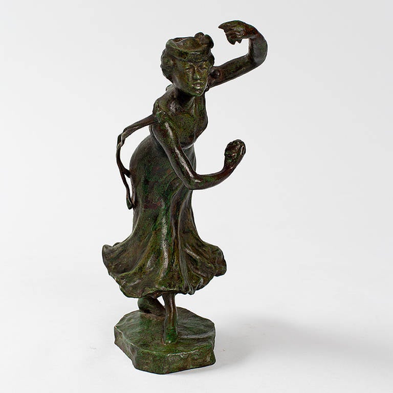 A French Art Nouveau patinated bronze figural sculpture of a castanets dancer by Rupert Carabin. The woman, in a dress with flowing hem and a headpiece, holds castanets in each hand. Carabin made a number of sculptures of dancers in different poses,
