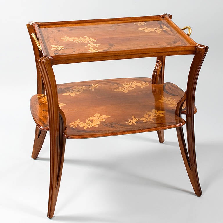 A French Art Nouveau two-tier table by Louis Majorelle, featuring fruitwood marquetry in a floral design depicting orchids, circa 1900. 
Pictured in The Paris Salons 1895-1914, Volume III: Furniture by Alastair Duncan, Antique Collectors’ Club