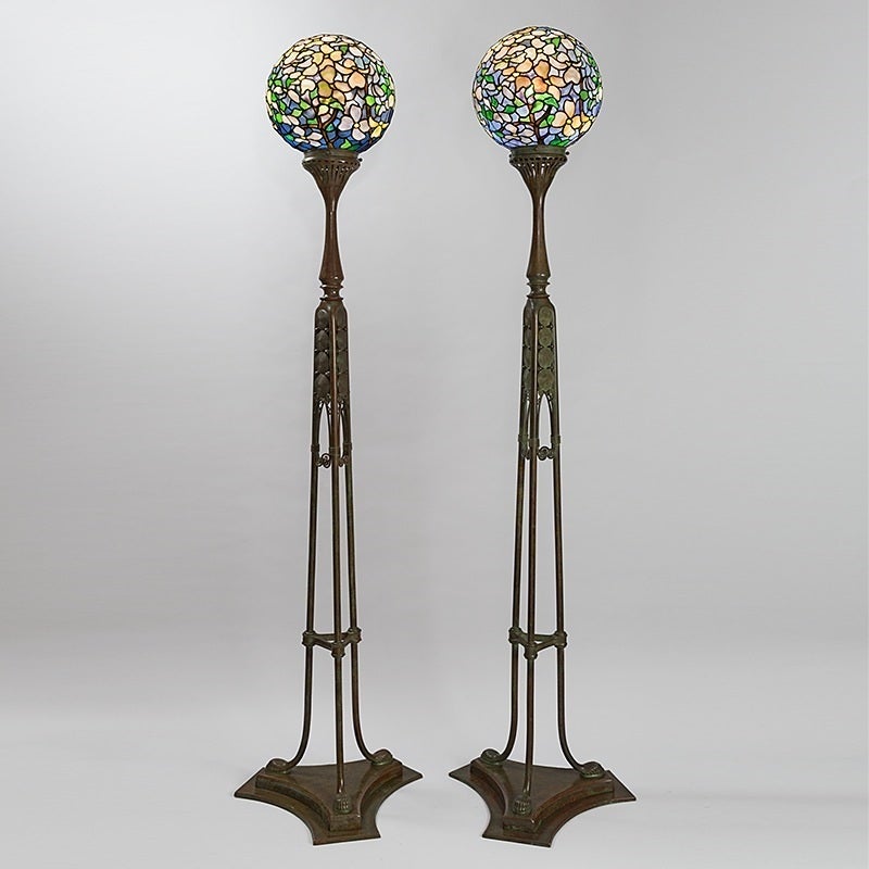 A pair of Tiffany Studios New York "Dogwood Ball" leaded glass and bronze floor lamps on tripod-form "Vinson" floor bases. These magnificent floor lamps were part of the interior furnishings of the Grand Hôtel in Stockholm in