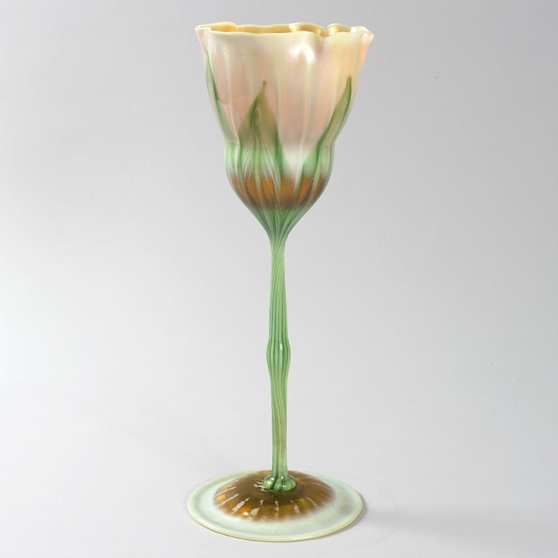  Tiffany Studios New York favrile glass flower form vase by Louis Comfort Tiffany. This floriform vase features a gold iridescent interior and green pulled feather decoration over a milky ground, circa 1900.

Favrile glass vases in the shapes of