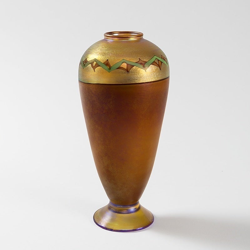 A Tiffany Studios New York Art Nouveau Favrile glass pedestal vase. Iridescent  sepia body with iridescent gold shoulders featuring a sage-green and beige Egyptian-inspired 'Tel el Armana