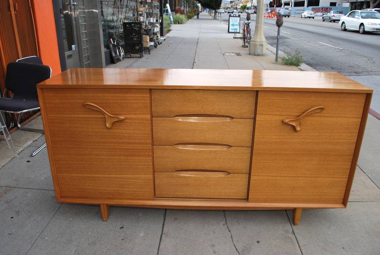 A very nice and iconic credenza by Paul Laszlo, it is his signature piece with these special handles, it is made of maple wood, the color and the patina is much nicer in person, it is called also a treasure chest, due to the fact it has
a lot of