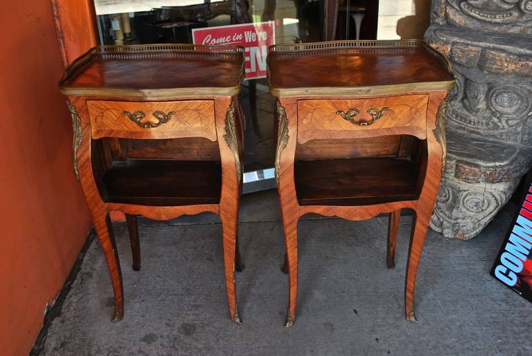 A beautiful pair of French side tables or night stands, they are quit unusual, with the handle in the back , they  also have a little Bombay style, with beautiful bronze,  and beautiful walnut  inlaid wood ,the picture speak for it self.