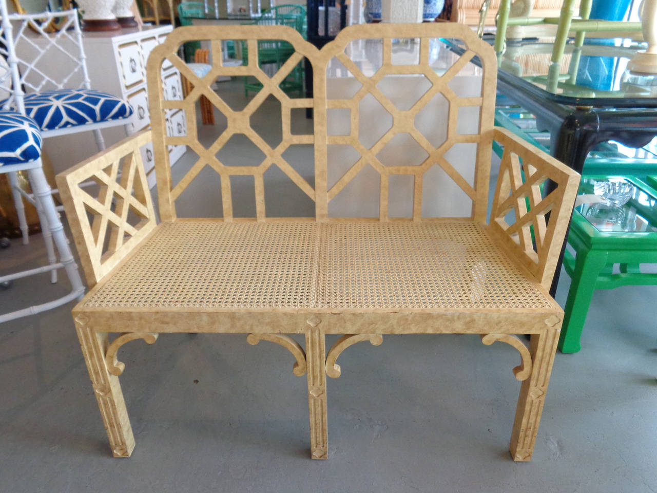 Hollywood Regency style fretwork settee with caned seat in nice as found vintage condition. There are scuffs, scrapes and chips to the as found finish.