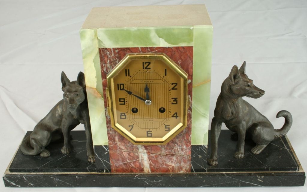 A colorful three-piece French Art Deco Style Mantle Clock Set in green, rose, and black marble with figures of German Shepherds and signed by Michel Laigle