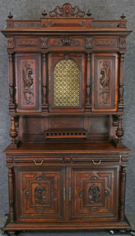 A French Renaissance Henry II style Buffet Sideboard Server in oak with unusual glass center door and elaborate carvings of dragons.