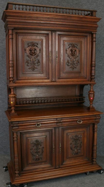 An Antique Renaissance-Style Buffet Server Sideboard from France in oak with charming carved heads of princes or courtiers.