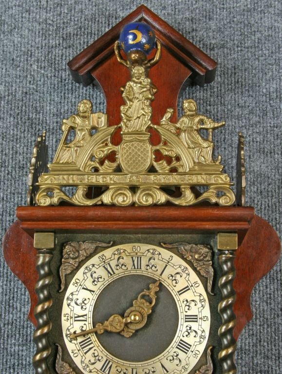 A vintage Zaandam Zaanse Style Pendulum Wall Clock from Holland dating to 1950 in mahogany and featuring the mythological figure of Atlas carrying the world on his shoulders at the top.