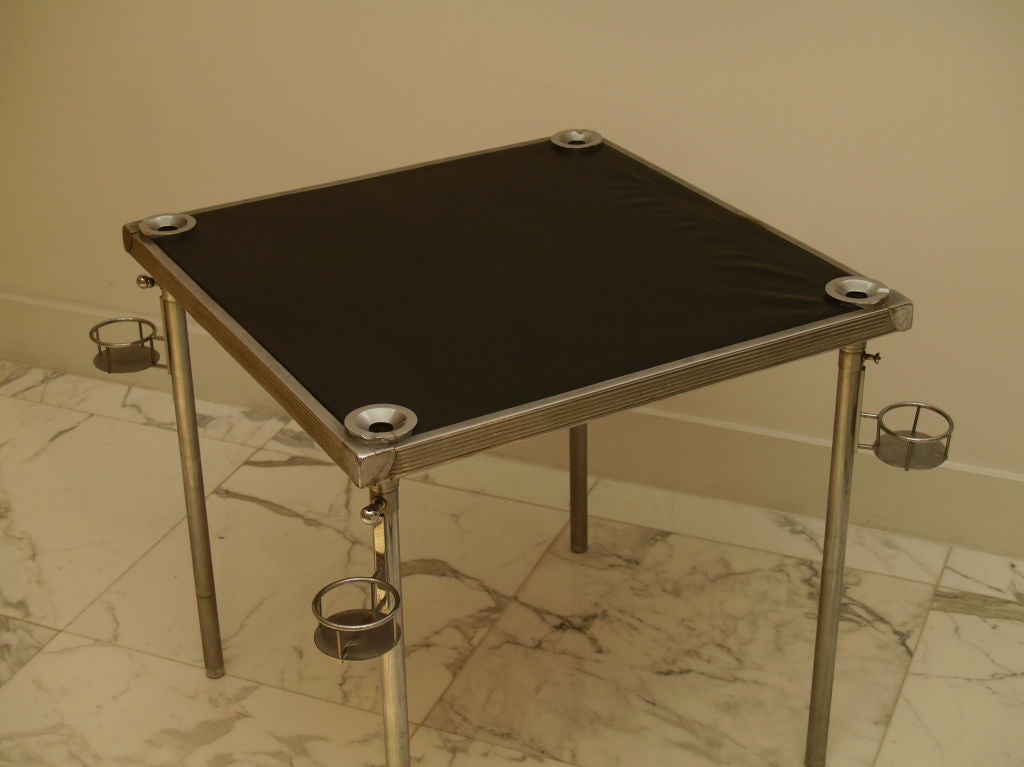 Gorgeous game table by Jacques Adnet, this table was designed with four glass holder, and four hidden ashtrays. The ashtrays are each of the legs, on each corner at the top of the table you can see the holes with you can place your cigar and dispose