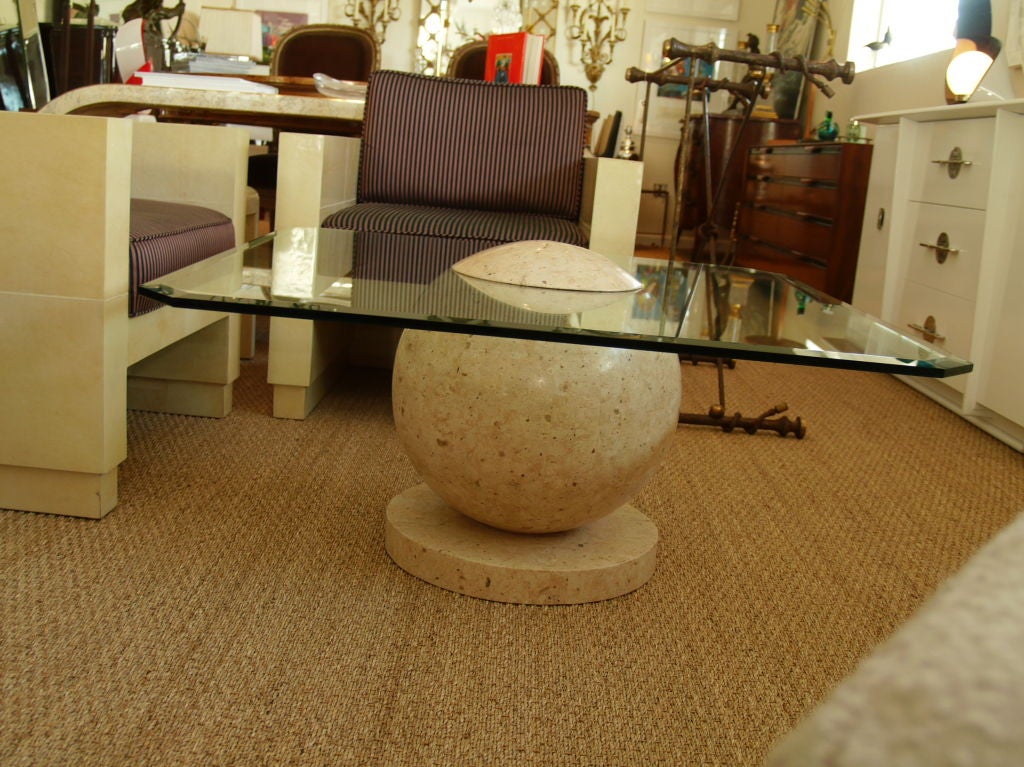 Une sphère orbitale décorative fusionnée dans une table basse avec un placage de marbre coloré dans un motif tesselé.
Un design unique de style 