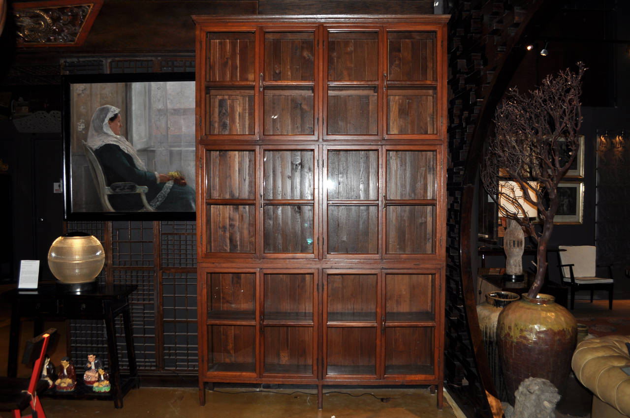 This unusually tall British Colonial bookcase came from Mandalay, Burma and is made from Teak Wood. It dates to the early 20th Century. Glass-fronted Teak Wood bookcases were popular in Colonial India and Burma because the scent of Teak repels