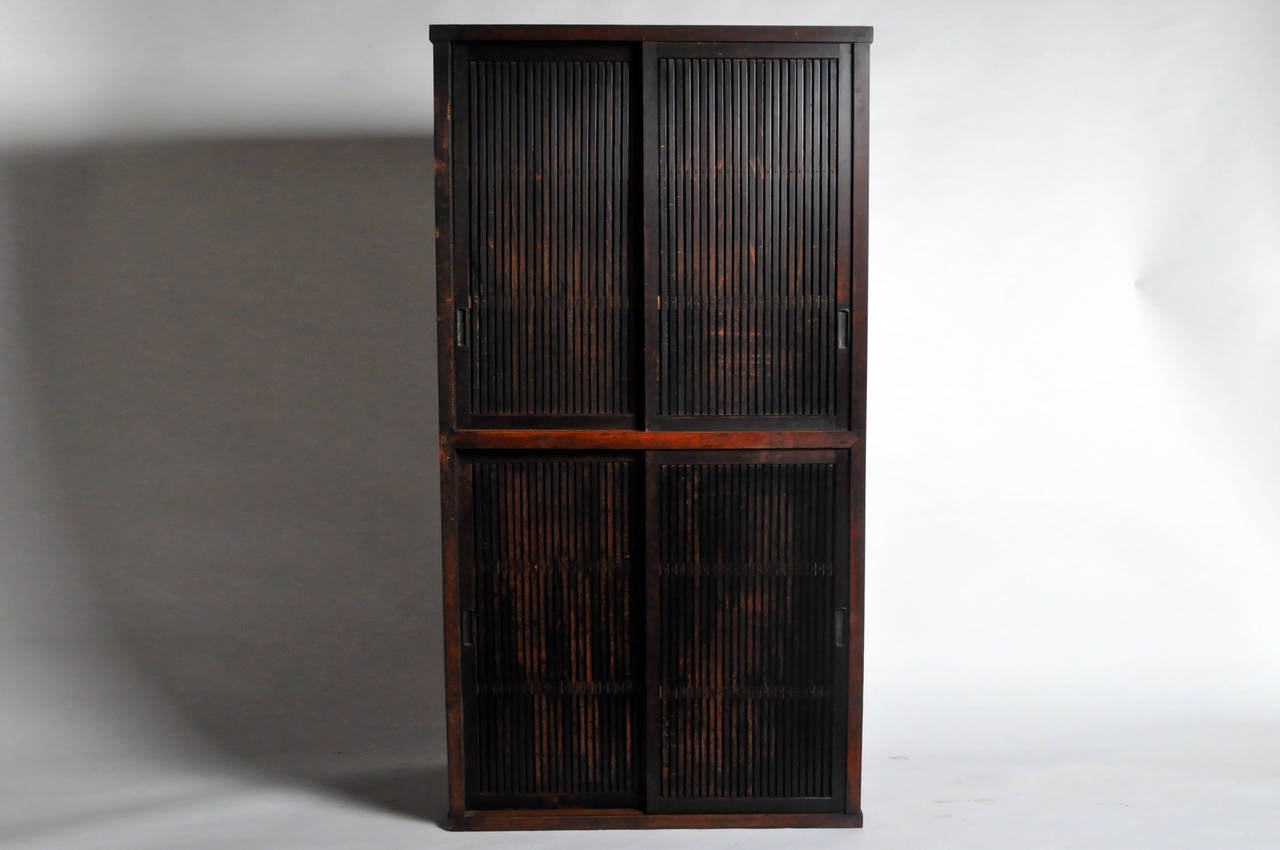 The distinctive feature of this 19th Century Japanese storage tansu is its verticality. Slim and tall, the vertical bars on the doors emphasize the cabinet's height. The piece has lovely old patina. Inside there has been no restoration. At the