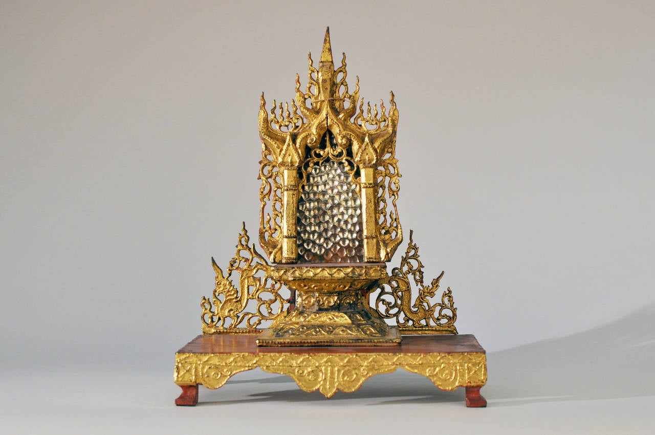 This exceptionally detailed Burmese Buddha shrine dates to the 19th century. Originally used to hold a sacred bronze Buddha figure, it is beautiful work of art on its own. The base is teakwood and it has been covered in red lacquered genuine