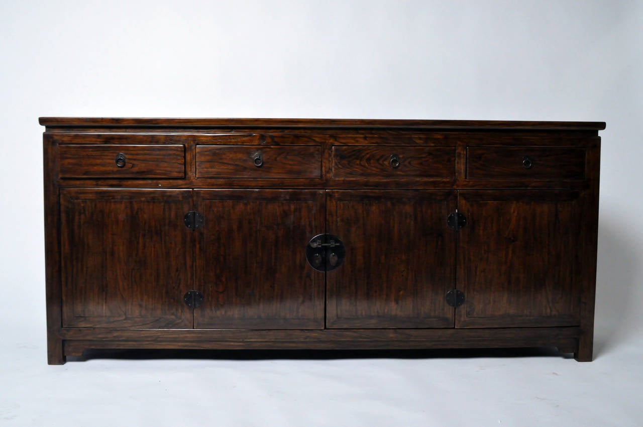 This impressive Chinese sideboard is from the Henan province of China and made from Elm Wood. This piece features bi-fold doors, 4 drawers, traditional mortise and tenon joinery, and has been professionally restored.