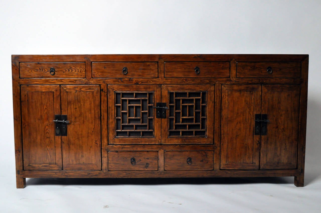 This squared-off sideboard has solid doors, drawers, and unusual lattice-fronted display area. This is a provincial piece; combining design elements and utilizing somewhat humble materials such as Fir Wood. Though fully restored, some pinkish