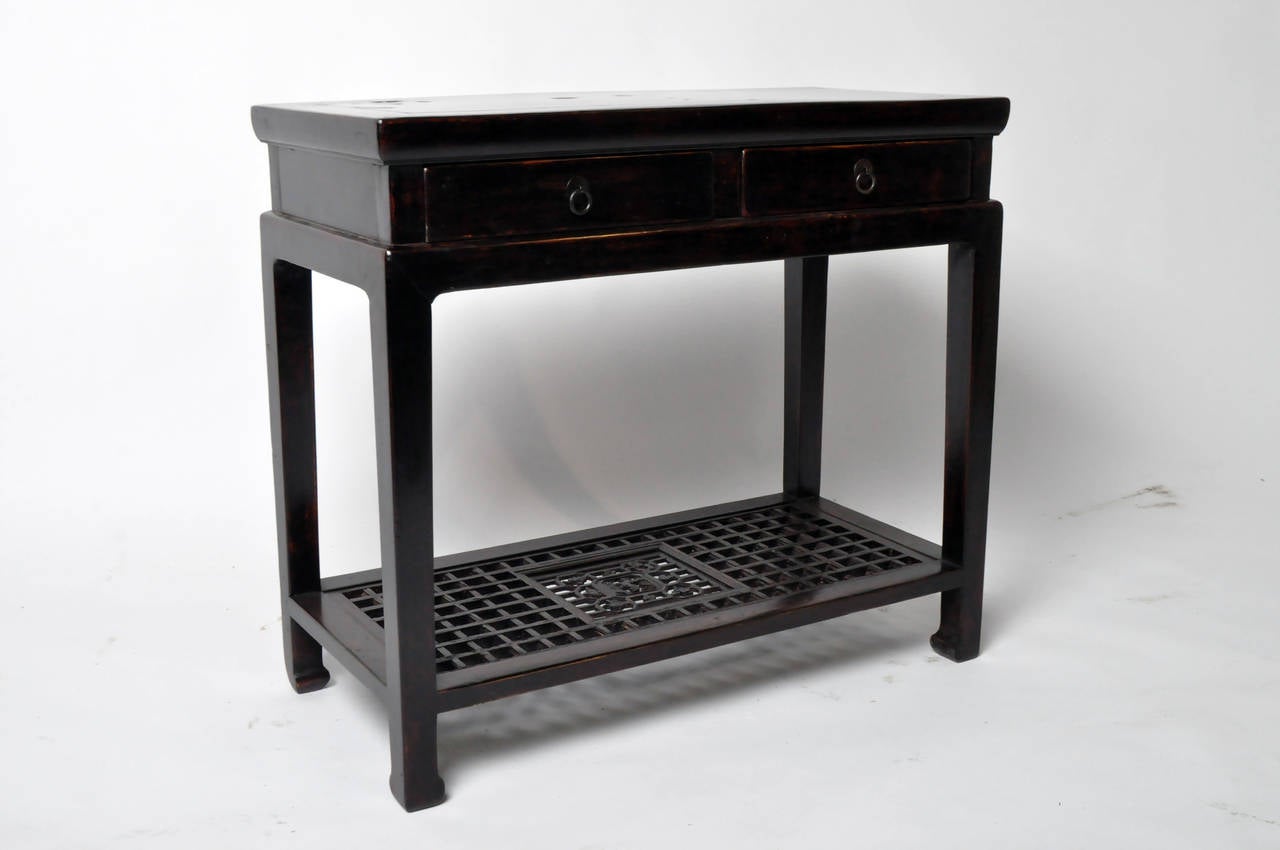 Classic black lacquer small console with lattice shelf. This piece has a strong visual presence despite its compact size. Fully restored, it has been French-polished for a smooth and dressy surface. The stone insert is marble.