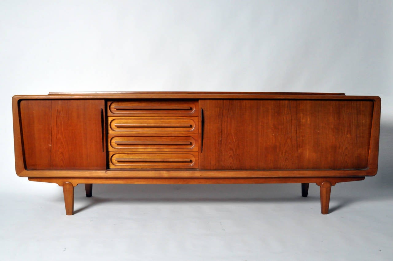 This impressive console is from Denmark and made by Vamo Sonderborg. It features a heavy and very solid Teak Wood frame, 2 large cupboard spaces, one with a tambour door, and a set of solid Teak drawers. Unlike many Mid-Century pieces this sideboard