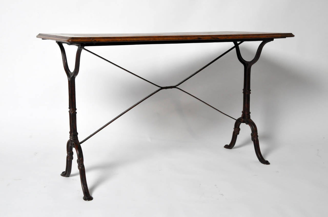 This Mid-Century bistro table is from France and made from Oak Wood. It features iron legs and beautiful aged patina. Table is sturdy and functional.