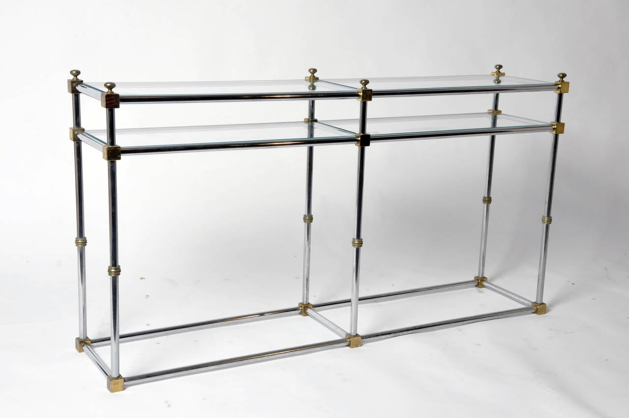 This elegant French console table is from Paris, France and made from steel, chrome, and glass. This console features a glass top and shelf.