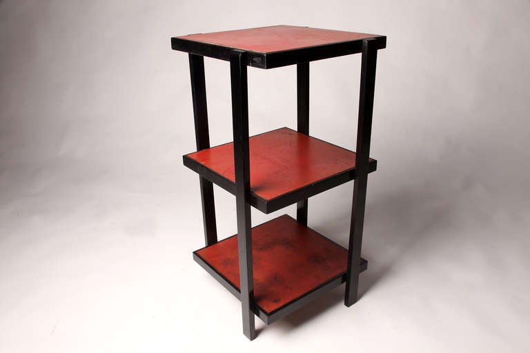 Made from red and black painted beechwood, this Stand has straight off-center legs.