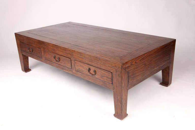 This amazing 19th century coffee table is from Suzhou, China and is made from elm wood. It has 3 drawers and had some restorations done on it.