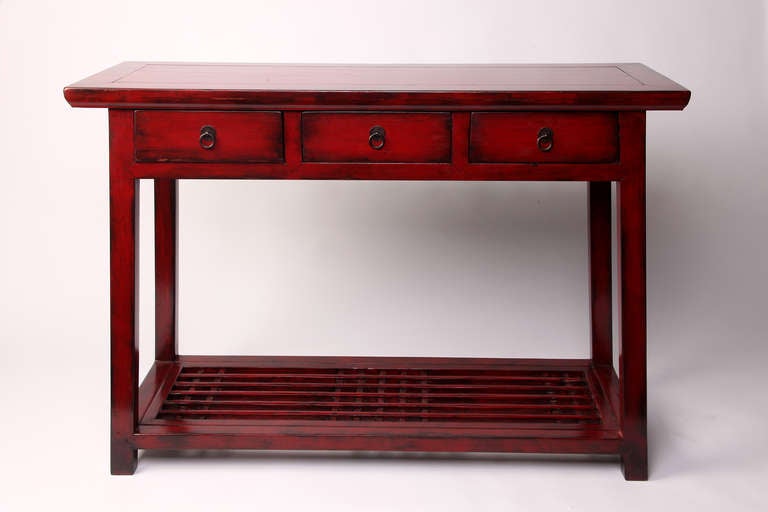 This 19th century console table is from Jiangsu, China and is made from elm wood. The console has  lacquer on the elm, 3 drawers, the lattice shelf, and had some restoration done.