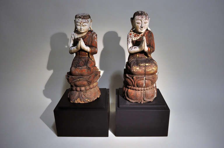 Depicting a Thai Buddhist monk kneeling atop a lotus blossom base, head slightly bowed and hands clasped in prayer. Still retaining much of the original lacquer decoration, it has been mounted a contemporary wood stand.