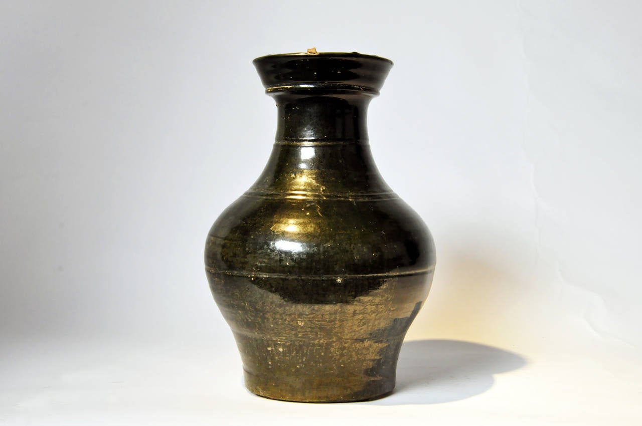 This vase has a rich, highly polished forest green colored glaze covering the exterior. Green-glazed ware like this dates to the Han Dynasty (206 BC to 220 AD), and is typically found in burial sites across China. There are three stilt fragments